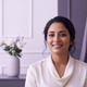 Close-up portrait of a happy South Asian woman in her late 20s to early 30s, smiling calmly.